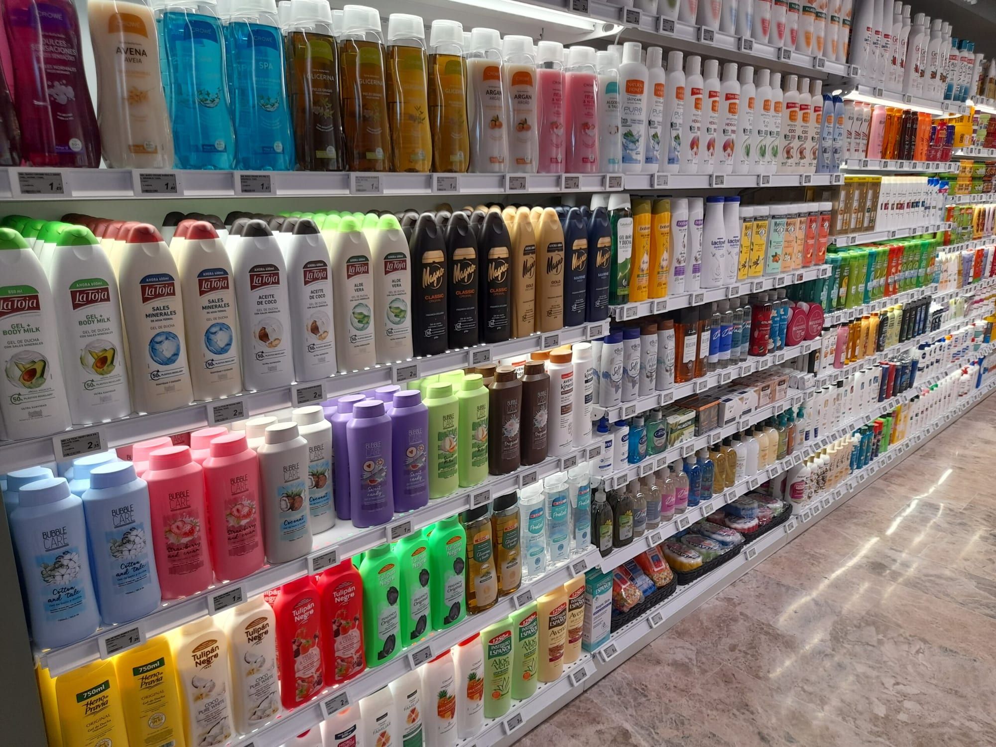 Pasillo de droguería con etiquetas electrónicas en cada referencia de champú y gel