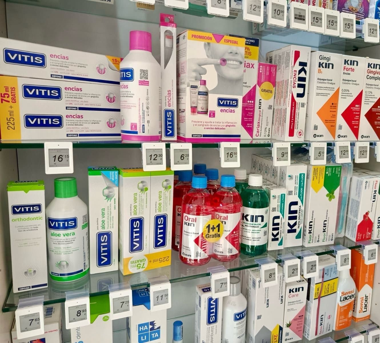 Estantería de farmacia con etiquetas electrónicas de precio en cada producto de higiene bucal
