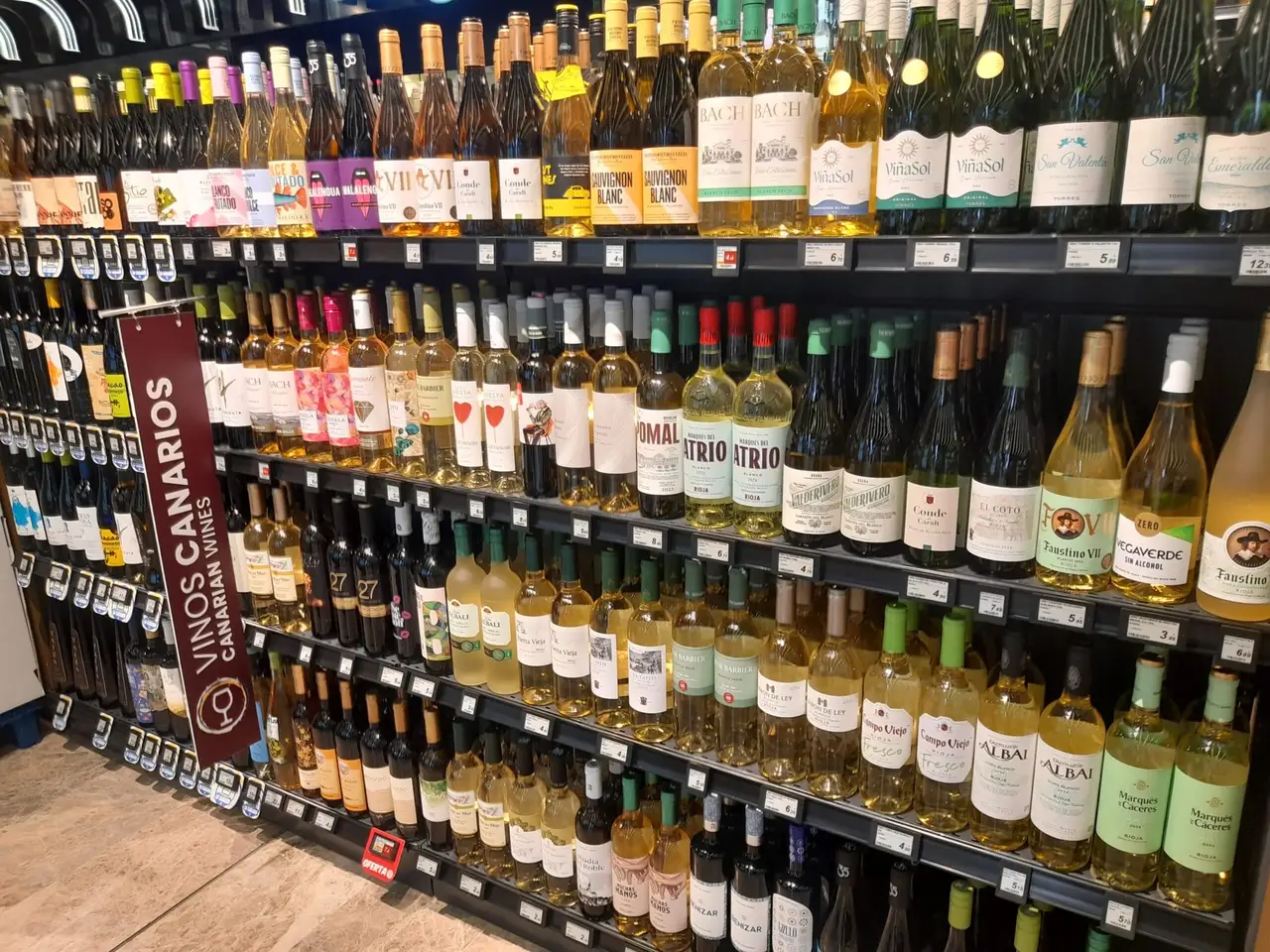 Lineal de vinos canarios de un supermercado con una etiqueta electrónica en cada referencia